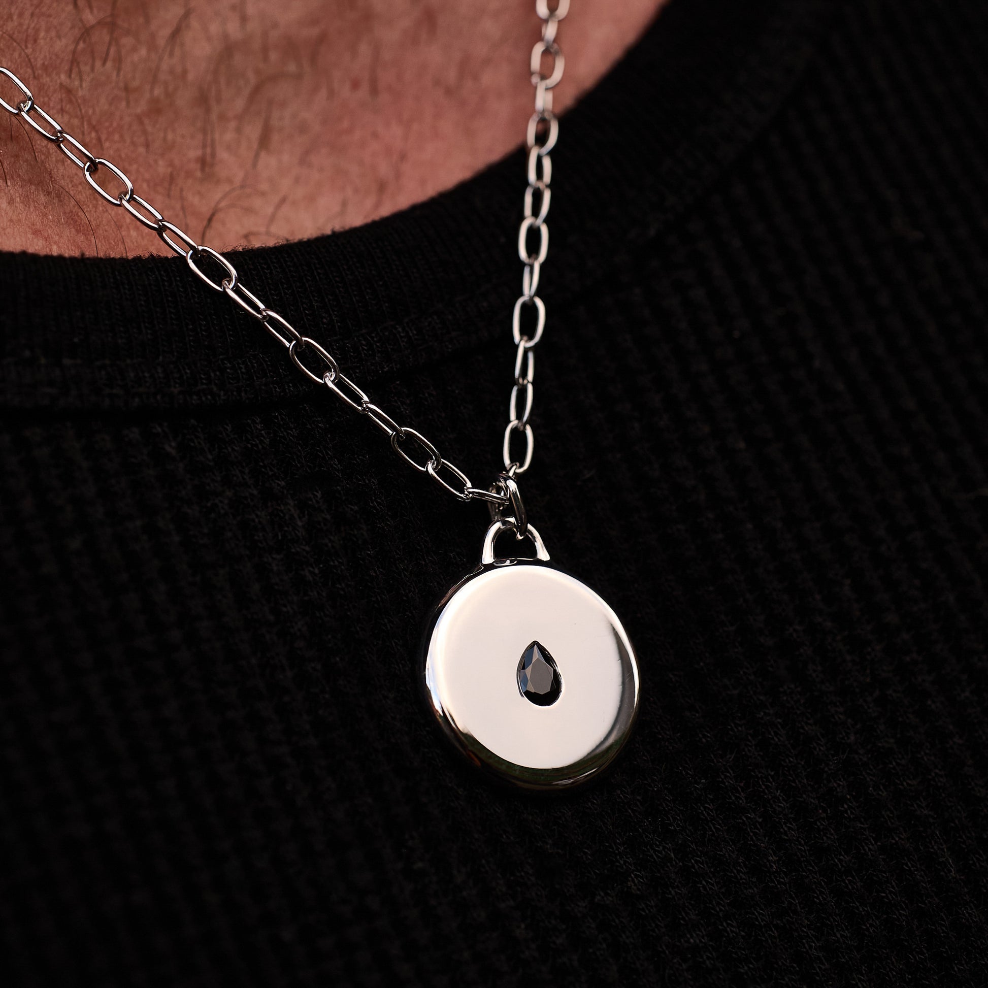 Close-up of a person wearing the Teardrop Pendant, featuring a black cubic zirconia stone set in rhodium-plated sterling silver, on a 52cm sterling silver chain.