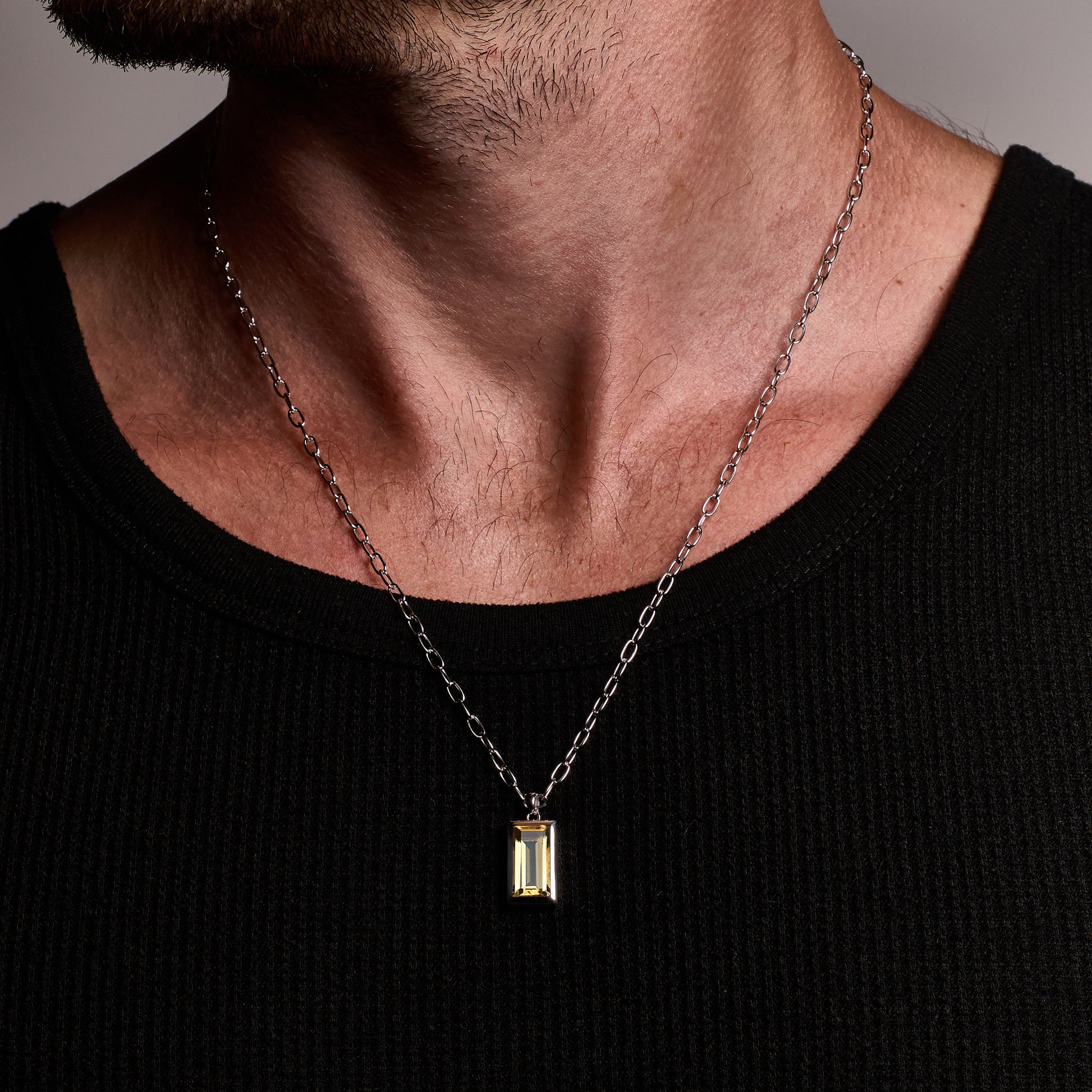 Close-up of a person wearing the Citrine Pendant, featuring a baguette-cut citrine stone set in rhodium-plated sterling silver with a 55cm sterling silver chain.